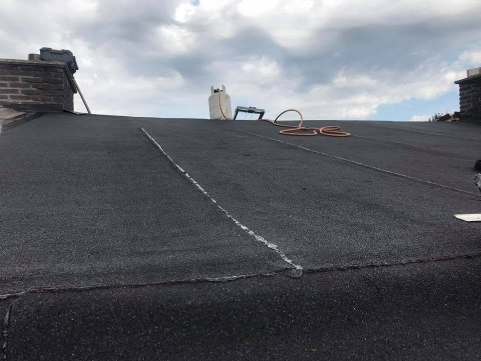 Nieuw gelegde bitumen dakbedekking op een plat dak